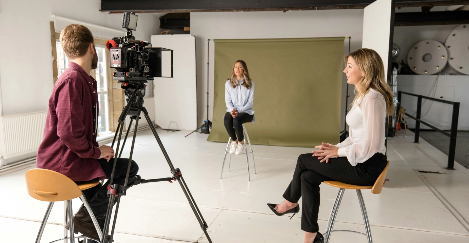 A stock image of three people in a room for a mock press interview
